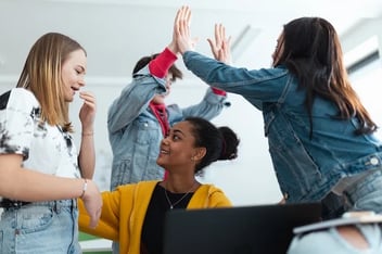 a group of young women standing around each other.