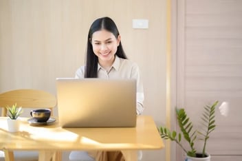 A woman sits back with satisfaction after creating a successful lead scoring in HubSpot.