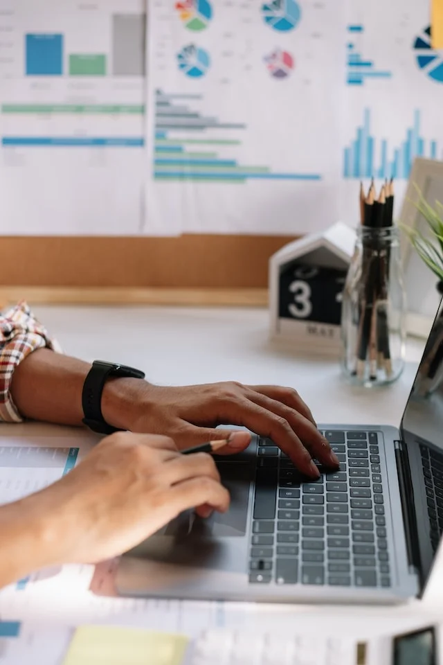 Ein Mann arbeitet an einem Laptop. Der Laptop zeigt eine Darstellung eines Sales Funnels in HubSpot.